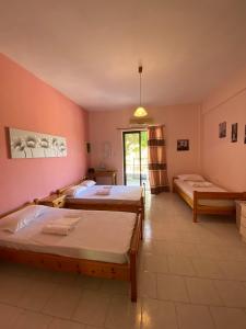 a room with two beds and a window at Yfantis Sakis Apartment's in Erateini