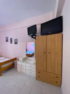 a room with a tv on top of a wall at Yfantis Sakis Apartment's in Erateini