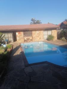 a swimming pool in front of a house at Rose-Lee Cottage in Durban
