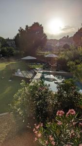 赫羅納的住宿－Torre de Can Puig，花园设有一座带遮阳伞和鲜花的游泳池