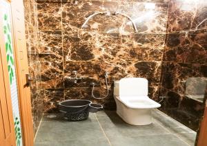 a bathroom with a toilet and a marble wall at Vaiga Homes - Vembanadu Lakeview Retreat in Cochin +81 photos
