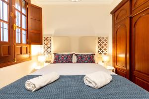 a bedroom with a bed with two towels on it at AoA Green Gardens Family House in Seville