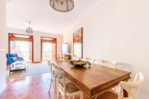 a dining room with a wooden table and chairs at AoA Green Gardens Family House in Seville