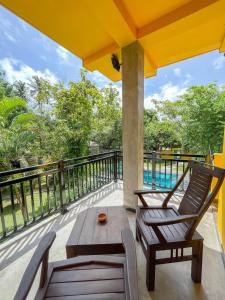 a patio with a table and chairs and a pool at Easy Living in Hikkaduwa