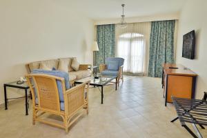 un soggiorno con un divano, sedie e un tavolo di Marina Plaza Hotel, Tala Bay ad Aqaba