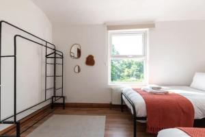 a white bedroom with a bed and a window at Metropolitan - 203 Millbrook Road East in Southampton