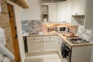 a small kitchen with a stove and a microwave at Swan House in Huddersfield