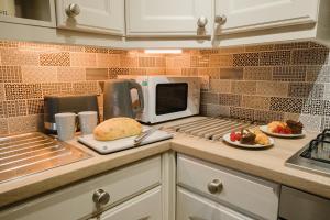 eine Küchentheke mit einer Mikrowelle und einem Teller mit Lebensmitteln in der Unterkunft Swan House in Huddersfield