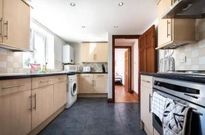 uma grande cozinha com armários brancos e uma máquina de lavar louça em Metropolitan - 203 Millbrook Road East em Southampton