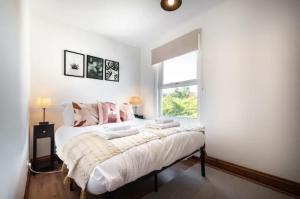 um quarto com uma cama com paredes brancas e uma janela em Metropolitan - 203 Millbrook Road East em Southampton