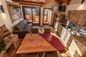 a kitchen and living room with a table and a couch at Appartamenti ABC Group in Sauze dʼOulx