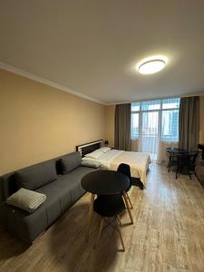 a living room with a couch and a bed and a table at Pirosmani Mini Hotel in Batumi