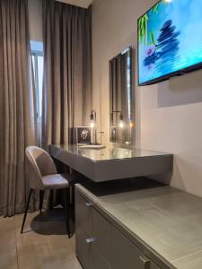 a bathroom with a desk and a television on a wall at Atlantic Affair Boutique Hotel in Cape Town