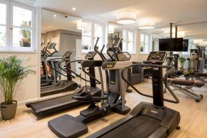 a gym with several treadmills and elliptical machines at Castille Paris – Starhotels Collezione in Paris