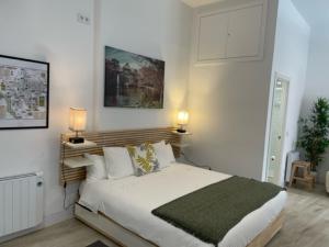 ein Schlafzimmer mit einem großen weißen Bett mit zwei Lampen in der Unterkunft (J3) Apartamento céntrico en Madrid in Madrid