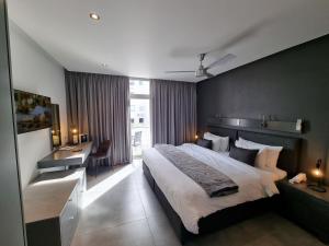 a hotel room with a large bed and a desk at Atlantic Affair Boutique Hotel in Cape Town