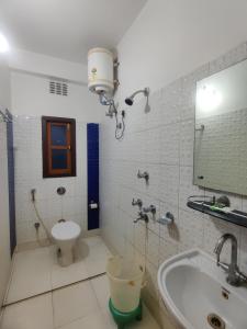 a bathroom with a sink and a toilet and a mirror at Hotel Swastik Regency in Siliguri