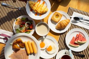 einen Tisch mit Frühstücksteller darauf in der Unterkunft Tour De Phuket Hotel - SHA Plus in Thalang