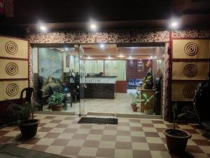a room with a lobby with potted plants at Hotel Swastik Regency in Siliguri