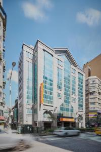 台北的住宿－福泰桔子商旅- 林森店，城市街道上一座高大的建筑,设有玻璃窗