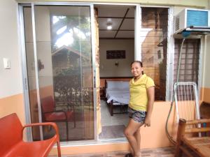 una mujer parada frente a una puerta corredera de cristal en Mango House Apartments en Panglao City