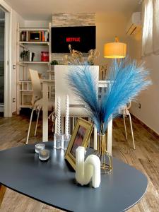 una sala de estar con una mesa con plumas azules. en The Attic, en Civitavecchia