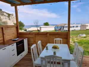a table and chairs on a deck with a view of the ocean at Camping Saint George in Topola