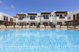 a large swimming pool in front of a building at La Malvarrosa in Puerto Calero