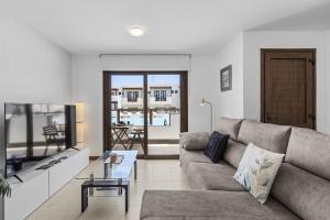 a living room with a couch and a tv at La Malvarrosa in Puerto Calero