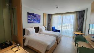 a hotel room with two beds and a television at Home Seview at Cam ranh Nha Trang Aparment in Cam Ranh