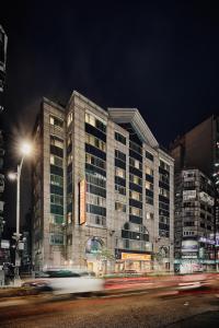 a large building at night with a street at Orange Hotel - Linsen, Taipei in Taipei