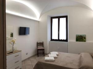 1 dormitorio con cama, ventana y silla en The House of the poet, en Civitavecchia