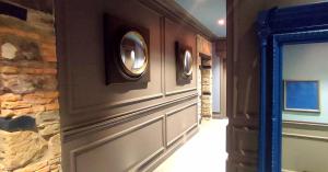 得利雅斯特的住宿－FORVM bijoux ROOMS，走廊上设有石墙和两面圆形镜子
