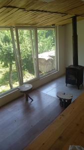 a living room with a large window and a stove at Dali Kaldanis Guest House in Becho in Mestia