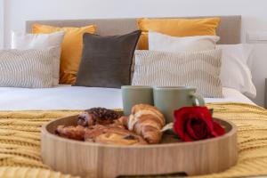 a tray of pastries and coffee cups on a bed at VACATION MARBELLA I Aldea Blanca, Luxury Duplex, Sea View, Walking Distance to Puerto Banus in Marbella