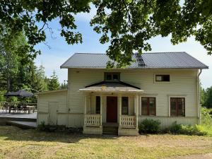 an old white house with a porch at Hassela Villa in Hassela