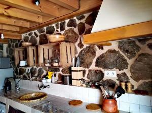 a kitchen with a stone wall and a counter top at Ca abuela María in Solana de ávila