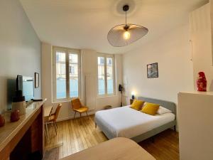 a bedroom with a bed with yellow pillows in it at Suite Clovis - 1 in Reims