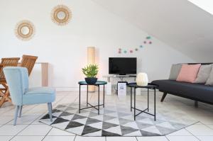 a living room with a couch and a tv at Le Bulbul - T2 à 100m de la plage - La Saline les Bains in La Saline les Bains