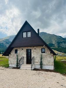 a small brick house with a black roof at Prima Vista in Žabljak