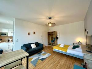ein Wohnzimmer mit einem Bett und einem Sofa in der Unterkunft Suite Clovis 5 in Reims