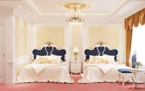 a bedroom with two beds and a chandelier at Hoang Gia Hotel Ha Noi Capital in Hanoi