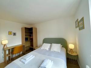 een kleine slaapkamer met een bed en een bureau bij Suite Clovis 7 in Reims