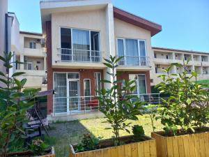 a house with a fence and plants in front of it at Apartment IMERI in Ureki