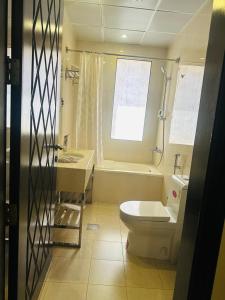 ein Badezimmer mit einem WC, einer Badewanne und einem Waschbecken in der Unterkunft كرم النخلة للشقق المخدومة in Riad