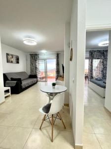 a living room with a table and a couch at One bedroom apartment ZEN with great view, pool, WiFi in Chayofa