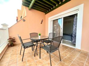 a table and chairs on a balcony with a table at One bedroom apartment ZEN with great view, pool, WiFi in Chayofa