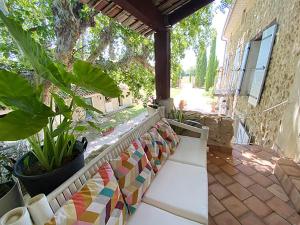 un porche con un banco con azulejos de colores. en Maison d'hôtes, superbe et spacieuse ,dans un cadre charmant calme et verdoyant en Pernes-les-Fontaines