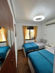 pokój z trzema łóżkami w pokoju w obiekcie Casa de Holm w mieście Torrevieja +37 zdjęć