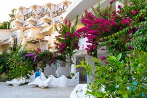 a building with pink flowers in front of it at Bougainville Bay Apartments in Sarandë